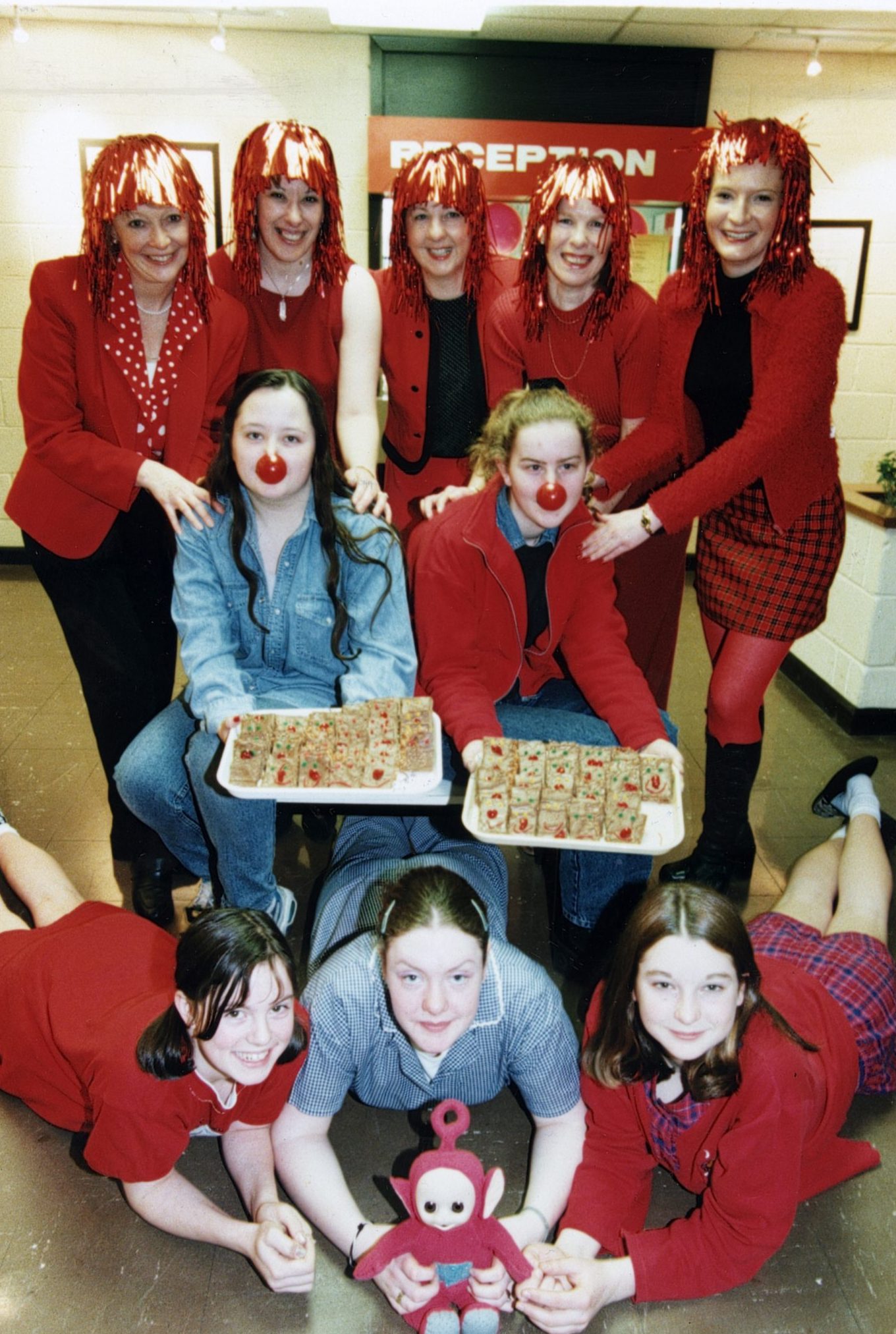 Pupils and staff with wigs and red noses pose with some tray bakes at the Comic Relief event at Arbroath High in 1999.