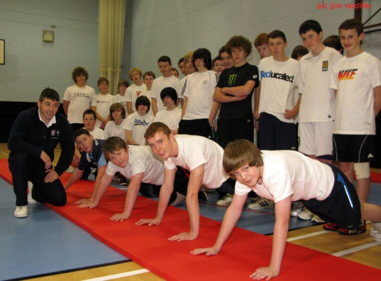 Paddy Stephens with the pupils, some of whom are doing press ups.