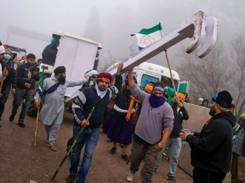 Indian farmers who have been protesting for a week to demand guaranteed crop prices wait to march to New Delhi near Shambhu border that divides northern Punjab and Haryana states (Altaf Qadri/AP)