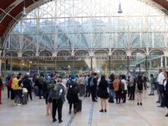 Passengers wait at Paddington station in London (Ashlee Ruggels/PA)