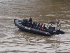 Members of the Metropolitan Police Marine Policing Unit pass near to Chelsea Bridge where they are due to search in relation to alkali attack suspect Abdul Ezedi (Lucy North/PA)