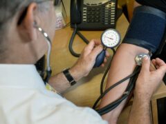 A GP checking a patient’s blood pressure (PA)