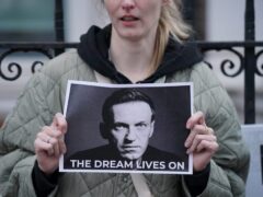 A protester holds a picture of Alexei Navalny at a protest opposite the Russian Embassy in London (Jonathan Brady/PA)