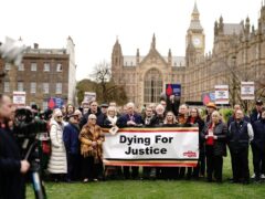 Infected blood victims and campaigners protest on College Green in Westminster (PA)