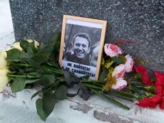 Screengrab taken from video shows flowers and a portrait of Russian opposition leader Alexei Navalny left in tribute to him by his mother Lyudmila Navalnaya at the memorial to victims of political repression in Salekhard, Russia (AP)
