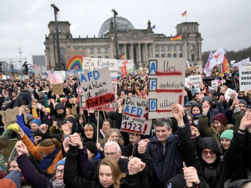People hold hands in front of Germany’s parliament Reichstag at a demonstration against the AfD party and right-wing extremism in Berlin, Germany (Ebrahim Noroozi/AP)