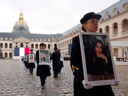 French Republican Guards hold portraits of the French victims of the October 7 2023 Hamas attack, during a ceremony at the Invalides monument (Gonzalo Fuentes/Pool via AP)