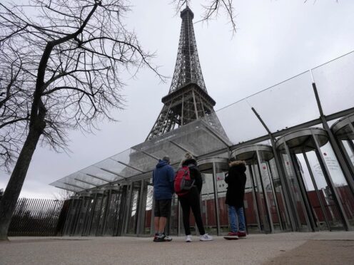 Visitors stand at the closed gates leading to the Eiffel Tower, which has been shut down due to strikes by workers (Michel Euler/AP)
