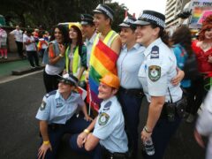 New South Wales state police pose with participants in an annual gay and lesbian Mardi Gras parade in Sydney (AP)