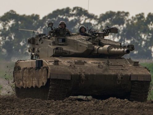 Israeli soldiers drive a tank near the Gaza Strip border, in southern Israel (Tsafrir Abayov/AP)
