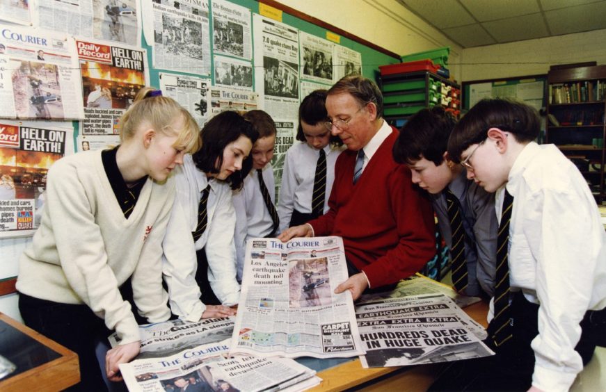 Teacher Keddie Law and some Arbroath Academy pupils look at newspapers.