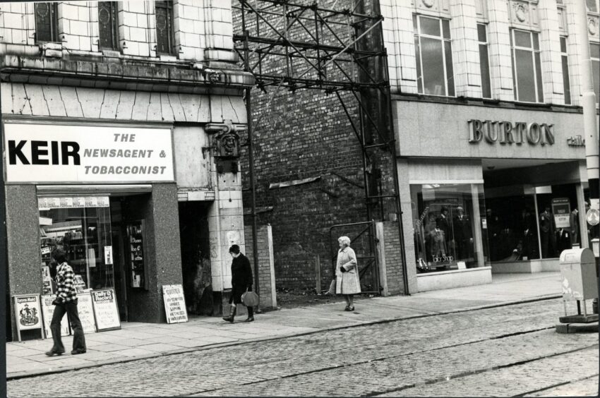 People walking past an empty space where the cinema used to be on Murraygate in 1976.