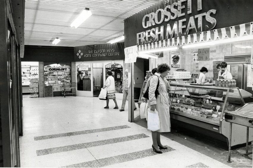 A woman looks at the display of Grossett Fresh Meats. 