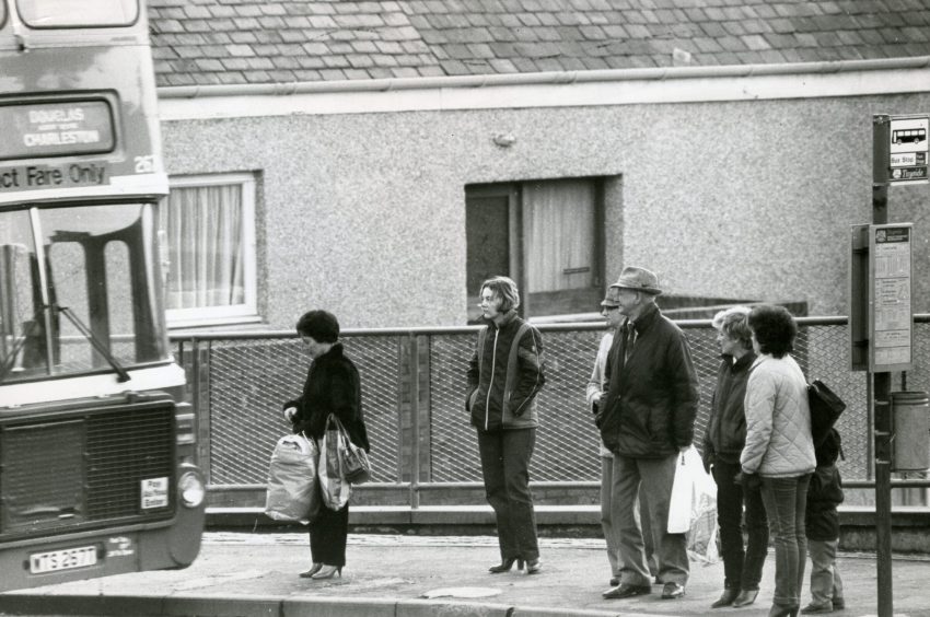 Passengers braving the chill in February 1983 as they wait to board a bus
