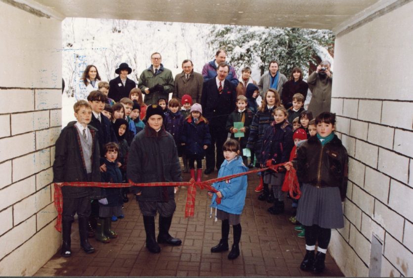 Youngsters cutting the subway ribbon.