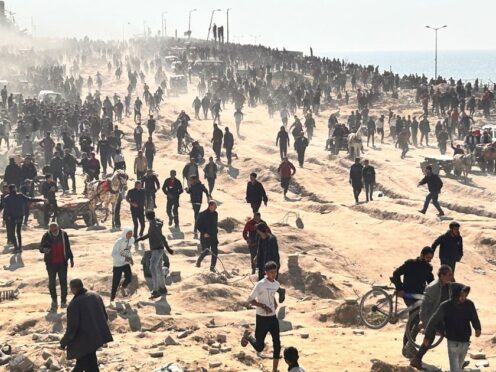 Palestinians wait for humanitarian aid on a beach in Gaza City (Mahmoud Essa/AP)