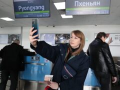 A Russian tourist, a member of a tour group travelling to North Korea first time since its borders closed due to the pandemic, takes a selfie after checking in (AP)