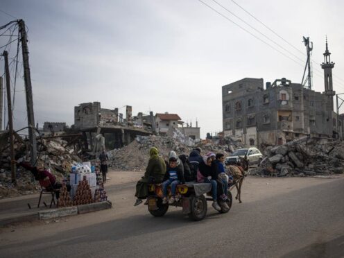 Palestinians ride on a donkey-drawn carriage next to buildings destroyed by an Israeli airstrike in Rafah, Gaza Strip (Fatima Shbair/AP)