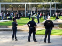 Police officers watch over churchgoers outside Lakewood Church, Texas after a reported shooting during a Spanish church service (Karen Warren/AP)