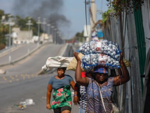 Street vendors run during clashes between police and gangs in Port-au-Prince, Haiti (Odelyn Joseph/AP)