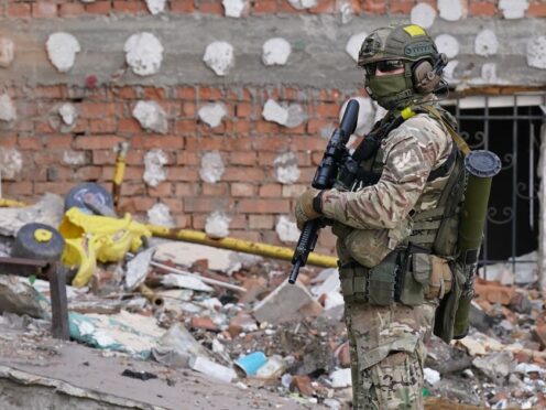 A Ukrainian soldier in front of bomb damaged buildings Irpin Kyiv Ukriaine. (Naill Carson/PA)