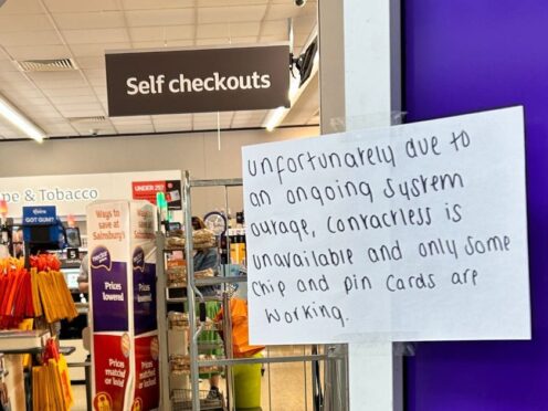 A hand written notice informing customers of technical issues at a Sainsbury’s in Huddersfield (Ashley Broadley/PA)