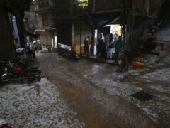 People stand inside a shop due to heavy hailstones rain in Peshawar (Mohammad Sajjad/AP/PA)