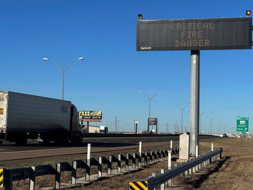 A truck passes a warning sign about the Smokehouse Creek Fire on a highway in Amarillo (Ty O’Neil/AP)