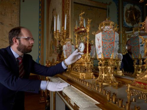 A horological conservator adjustsa late-18th-century French mantelclock at Buckingham Palace (Royal Collection Trust/PA)