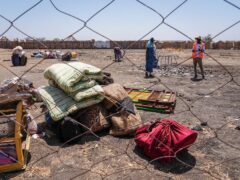 The belongings of people who crossed the border from Sudan sit in a yard at the Joda border crossing in South Sudan (AP)