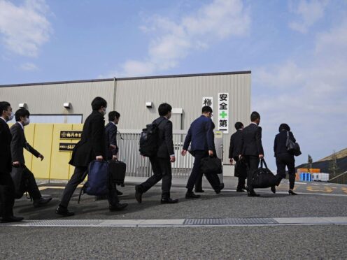 Japan’s health ministry officials walk into a plant operated by a subsidiary of Kobayashi Pharmaceutical (Yohei Fukai/Kyodo News/AP)
