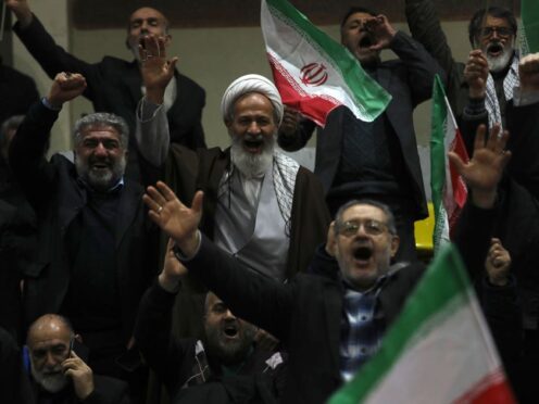 Supporters of a group of candidates chant slogans during their election campaign rally (Vahid Salemi/AP)