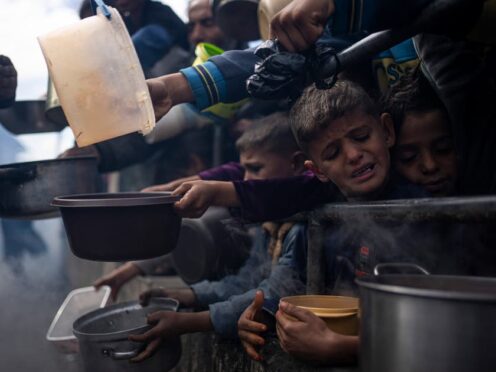 Palestinians line up for a free meal in Rafah (Fatima Shbair/AP)