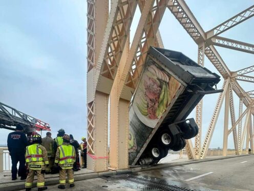 The lorry was left dangling off the Clark Memorial Bridge over the Ohio River (Louisville Division of Fire via AP)