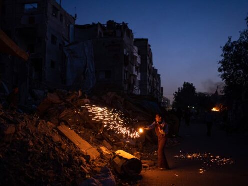 A Palestinian boy plays with fireworks as he celebrates the start of Ramadan (AP)