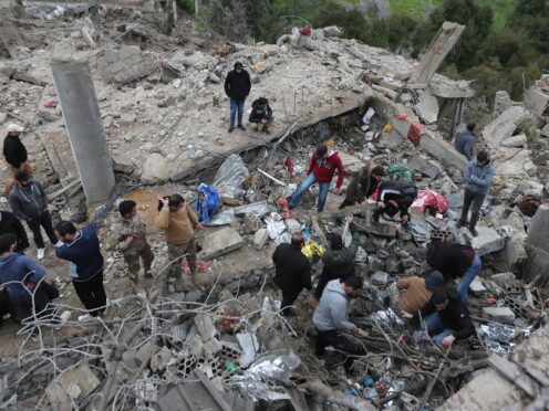 People search for victims in the rubble of a paramedic centre that was destroyed by an Israeli air strike in Hebbariye village, south Lebanon (AP)