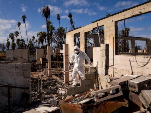 Resident minister of the Lahaina Hongwanji Mission Reverend Ai Hironaka walks through the grounds of his temple and residence destroyed by the August wildfiref (Lindsey Wasson/AP)