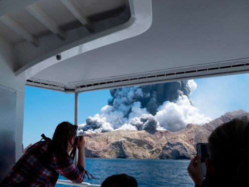 Photo provided by Michael Schade shows tourists on a boat looking at the eruption of the volcano on White Island (Michael Schade/AP)