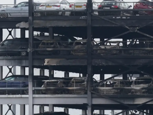 The burned-out shells of cars, buried among debris of a multi-storey car park at Luton Airport, Wednesday, after fire ripped through the structure (Jacob King/PA)