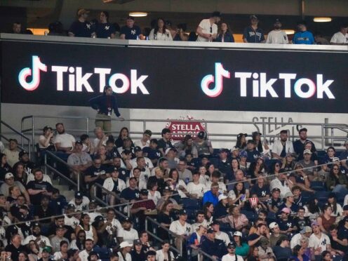 Fans sit under a TikTok ad at a baseball game at Yankee Stadium, April 14, 2023, in New York (Frank Franklin II/AP)