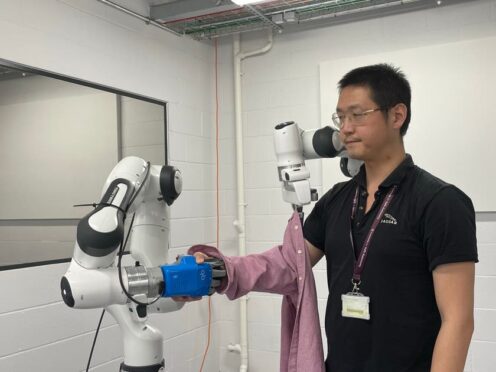 Dr Jihong Zhu testing out a robot dresser (University of York/PA)