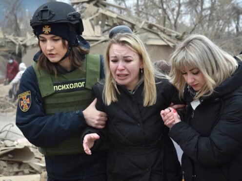 A woman is supported at the site of Russia’s air attack in Zaporizhzhia (AP)