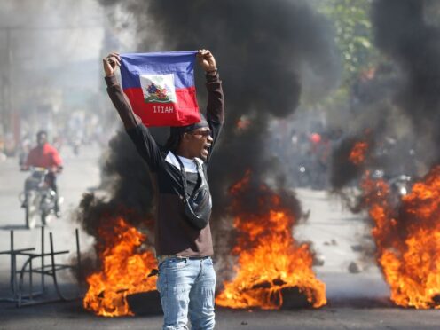 A demonstrator holds up an Haitian flag during protests demanding the resignation of Prime Minister Ariel Henry in Port-au-Prince, Haiti (AP)