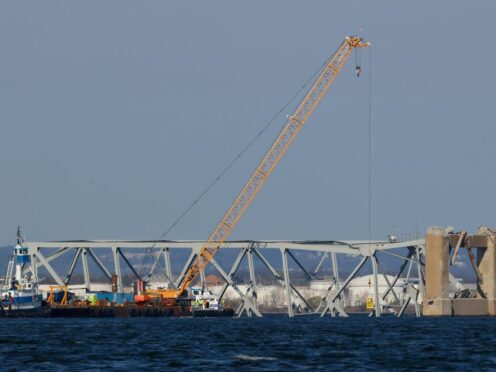 Workers in a crane-held basket mark lines on a damaged section of the Francis Scott Key Bridge (Julia Nikhinson/AP/PA)