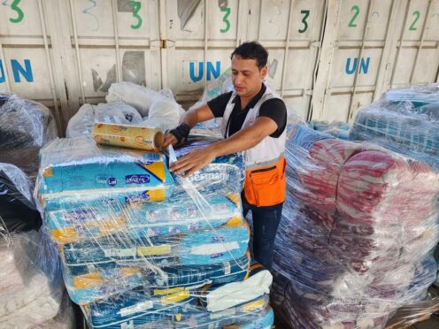 A United Nations worker prepares aid for distribution to Palestinians (Hassan Eslaiah/AP)