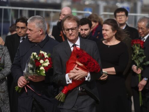 British deputy head of mission to Russia Tom Dodd (centre) laid flowers in Moscow (Sergei Ilnitsky/Pool Photo via AP)