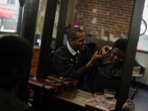 A customer has her hair trimmed in a hairdressing salon in Paris (AP Photo/Thibault Camus)