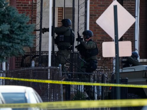 Police officers entering a home in Trenton, New Jersey, on Saturday (Matt Rourke/AP)