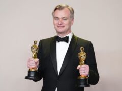 Christopher Nolan poses in the press room with the awards for best director and best picture for Oppenheimer (Jordan Strauss/Invision/AP/PA)