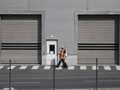 Fire department employees walk outside the Tesla car factory after production came to a standstill and workers were evacuated following a power outage, in Grünheide, Germany (Sebastian Gollnow/AP)
